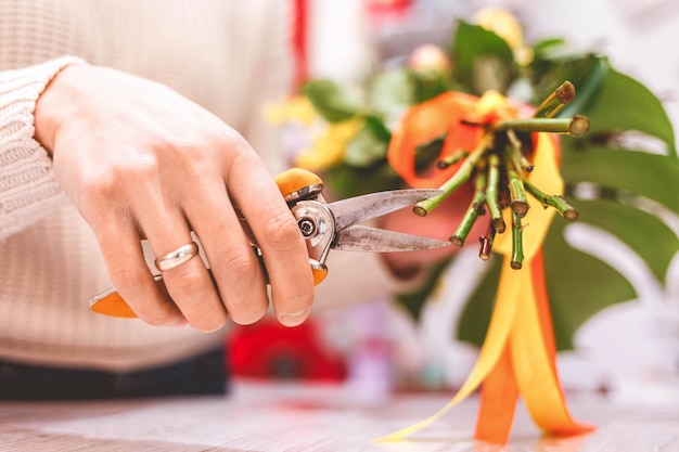 Fleuriste élagage femme rose sur bouquet dans la boutique de fleurs