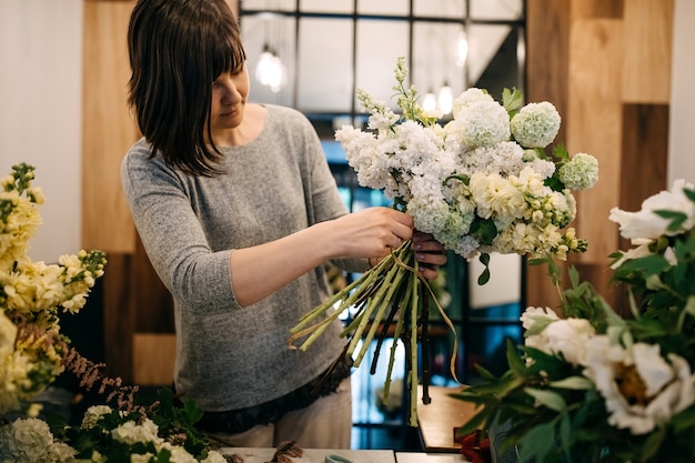 Fleuriste faisant un bouquet dans un magasin de fleurs