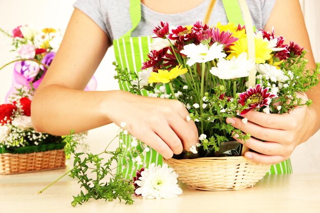 Photo le fleuriste fait le bouquet de fleurs dans le panier en osier