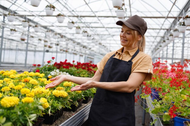 Une fleuriste fait la démonstration de produits dans une serre à fleurs