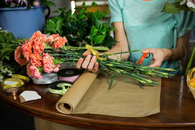 Fleuriste femelle coupe tige de fleur