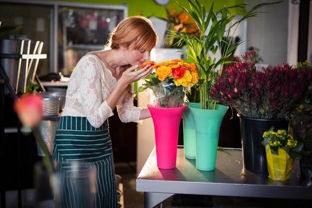 Fleuriste femelle sentant les fleurs roses