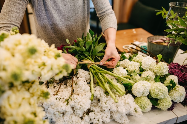 Fleuriste femme faisant un bouquet dans un magasin de fleurs