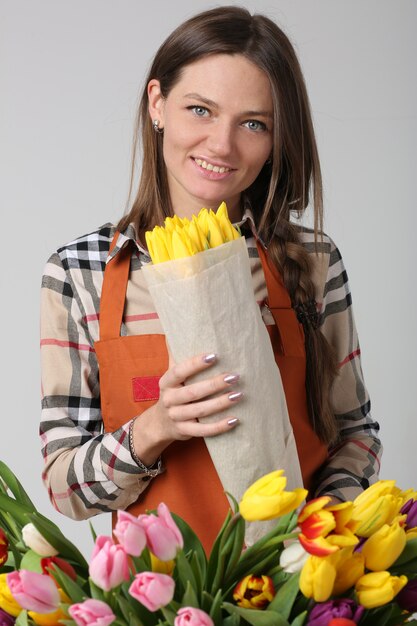 Fleuriste femme sur gris avec tulipes