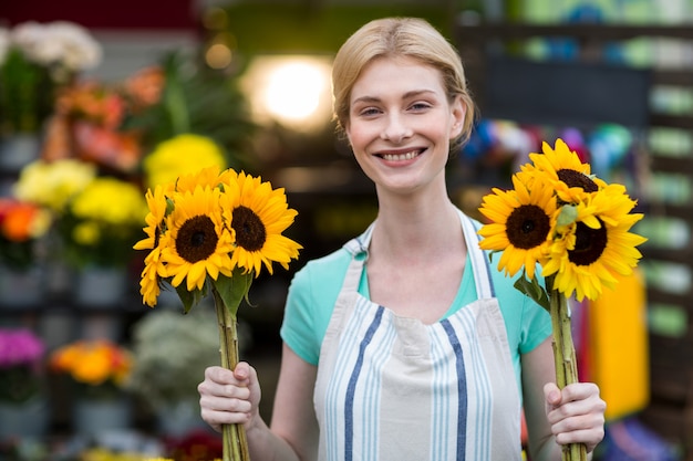 Fleuriste femme tenant des fleurs dans un magasin de fleurs