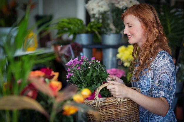 Fleuriste femme tenant un panier de fleurs