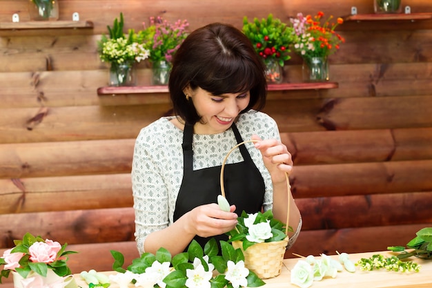 La fleuriste de fille rassemble un bouquet des fleurs et du savon artificiels