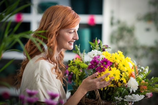 Fleuriste heureux holding panier de fleurs