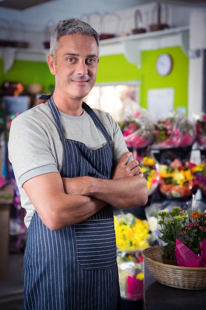 Fleuriste mâle debout avec les bras croisés