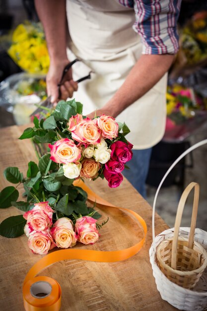 Fleuriste mâle prépare un bouquet de fleurs