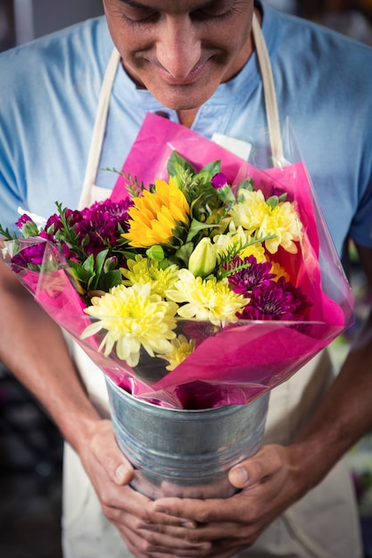 Fleuriste mâle sentant la fleur