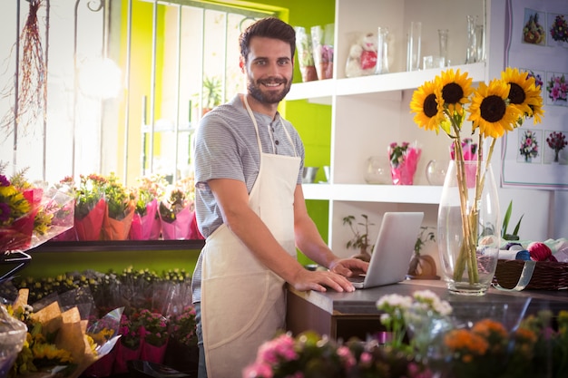 Fleuriste masculin à l'aide d'un ordinateur portable