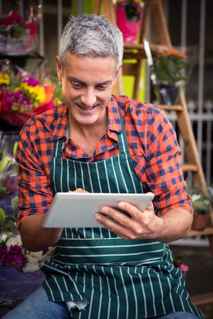 Fleuriste masculin à l'aide de tablette numérique