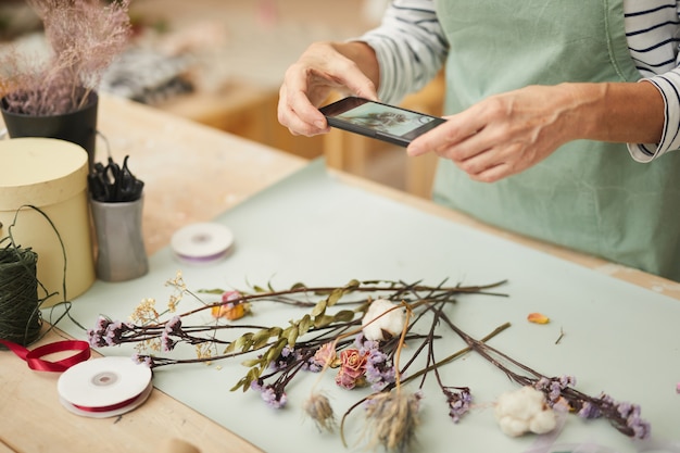 Fleuriste méconnaissable prenant une photo