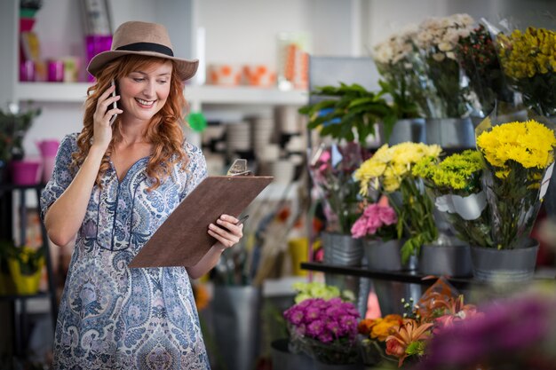 Fleuriste prenant la commande sur téléphone mobile