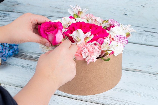 Photo fleuriste prépare un bouquet de roses roses et rouges