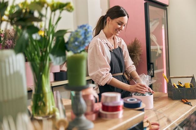 Fleuriste professionnel jeune femme faisant des bouquets au magasin de fleurs