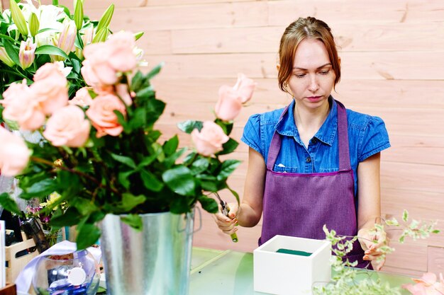 Fleuriste de trois filles travaillant avec des fleurs