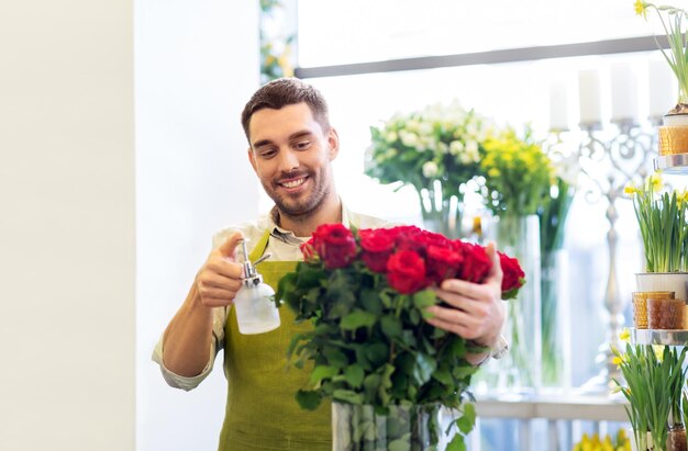 Photo fleuriste ou vendeur posant des roses rouges dans une boutique de fleurs