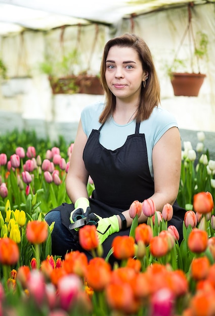 Fleuristes femme travaillant avec des fleurs tulipes dans une serre au printemps