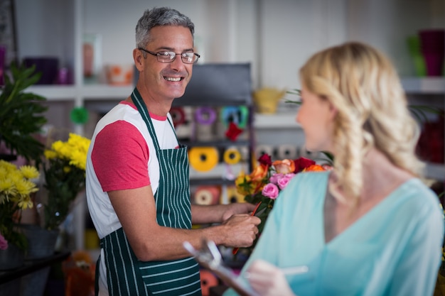 Fleuristes souriants interagissant les uns avec les autres