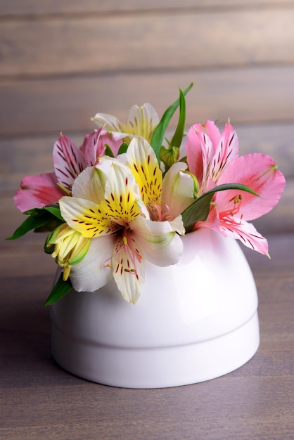 Fleurs d'Alstroemeria dans un vase sur table sur fond gris