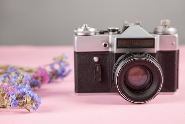 Fleurs avec appareil photo vintage sur la table