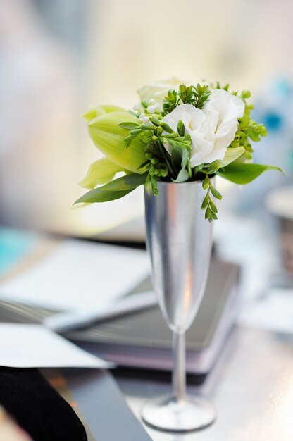 Fleurs blanches dans un vase argenté comme décoration sur la table