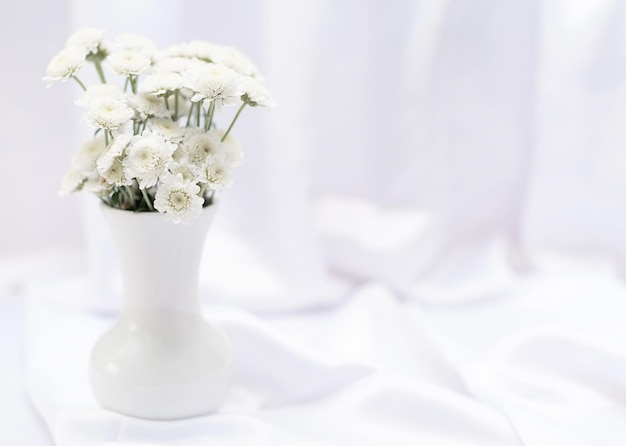 Fleurs blanches dans un vase blanc sur fond blanc avec espace de copie et mise au point sélective Carte de voeux ou d'invitation