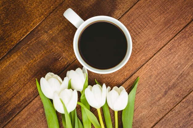 Fleurs blanches et une tasse de café