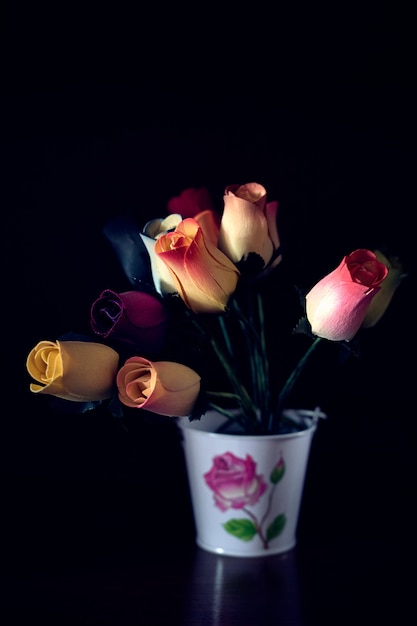 Fleurs en bois dans un vase en métal blanc