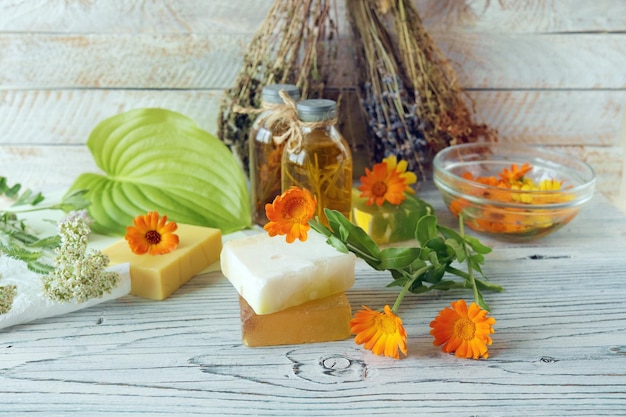 Fleurs de calendula, savon, huiles et teintures, sur fond de bois, ingrédients naturels