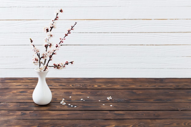 Fleurs de cerisier dans un vase sur une table en bois