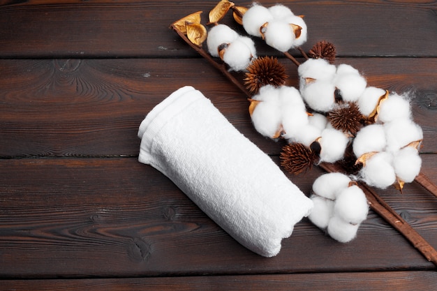 Photo fleurs de coton avec une serviette sur une table en bois