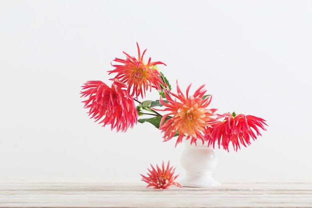 Fleurs de Dahlia dans un vase blanc sur une table en bois