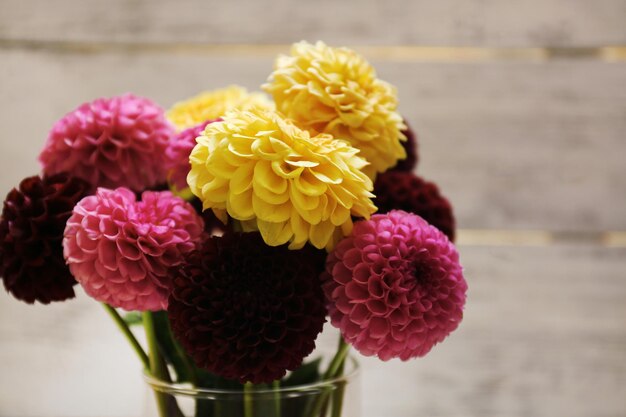 Fleurs de dahlia dans un vase sur une table en bois