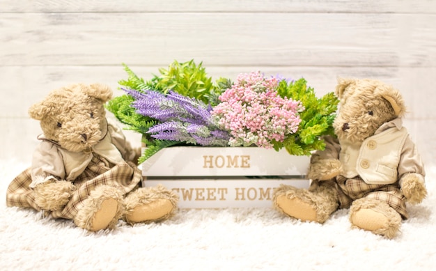 Fleurs dans une boîte en bois et des ours mignons. Fleurs dans une boîte blanche, ours en peluche vintage. romain