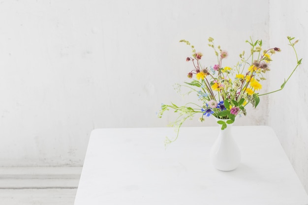 Fleurs dans un vase blanc à l'intérieur vintage blanc