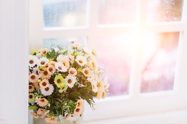 Fleurs dans un vase sur la fenêtre