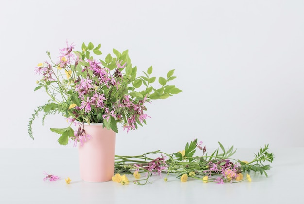 Fleurs d'été dans un vase sur fond blanc