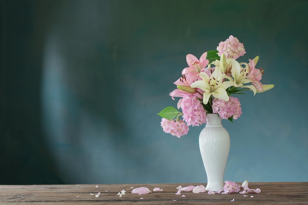 Fleurs d'été dans un vase vintage blanc sur fond sombre