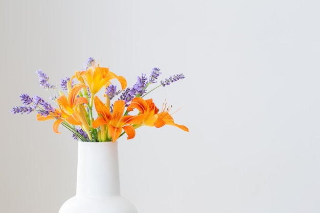 Fleurs d'été en pot blanc sur étagère en bois