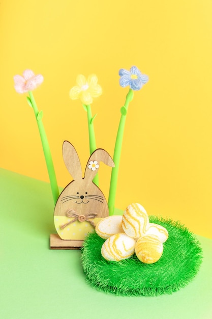 Fleurs de fil de lapin en bois rond tapis d'herbe décoratif avec des oeufs de Pâques texturés sur jaune vert