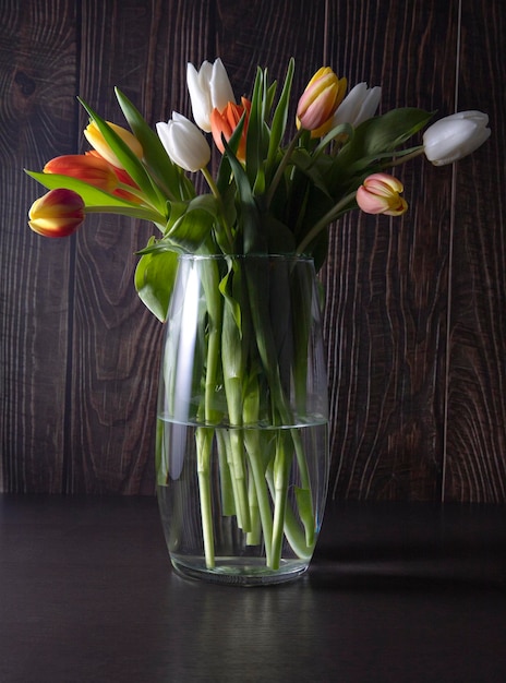 fleurs fraîches et printanières dans un vase sur fond sombre