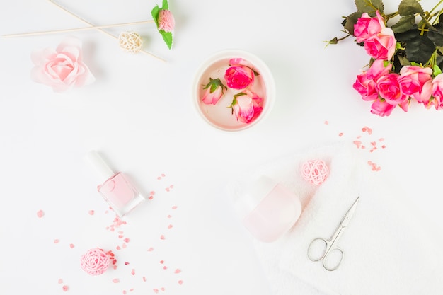 Fleurs fraîches avec des produits cosmétiques sur fond blanc