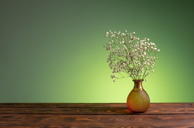 Fleurs de gypsophile dans un vase sur fond vert