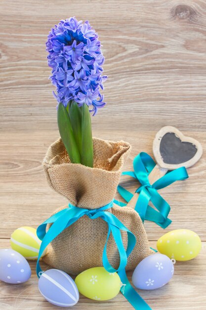 Fleurs de jacinthe bleue avec des oeufs de Pâques sur table en bois