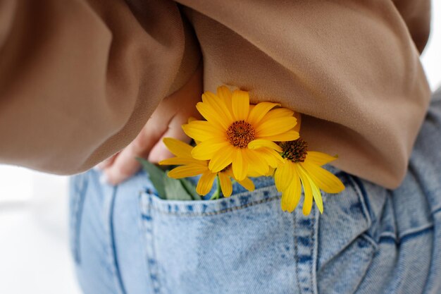 Fleurs jaunes dans l'humeur gros plan de la poche de jeans