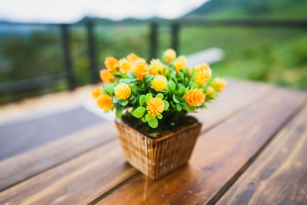 Fleurs jaunes dans un vase sur table en bois