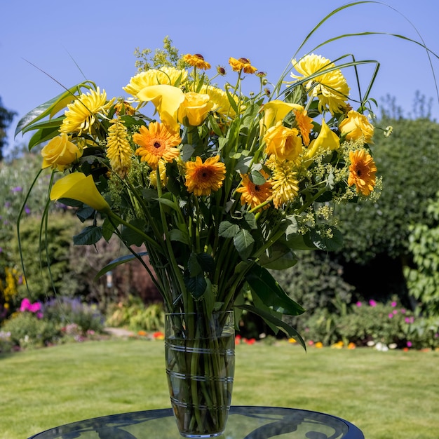 Fleurs jaunes dans un vase sur une table de jardin